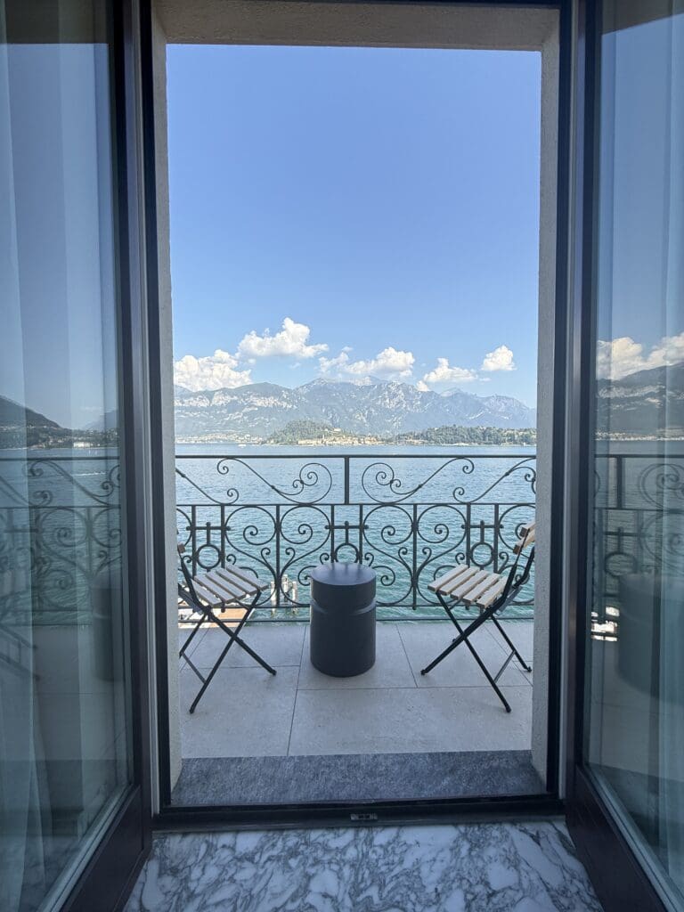 Open balcony doors overlooking the lake and mountains from a Lake Como EDITION guest room